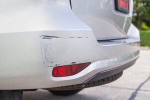 Backside of new silver SUV car get scratched, damaged by accident